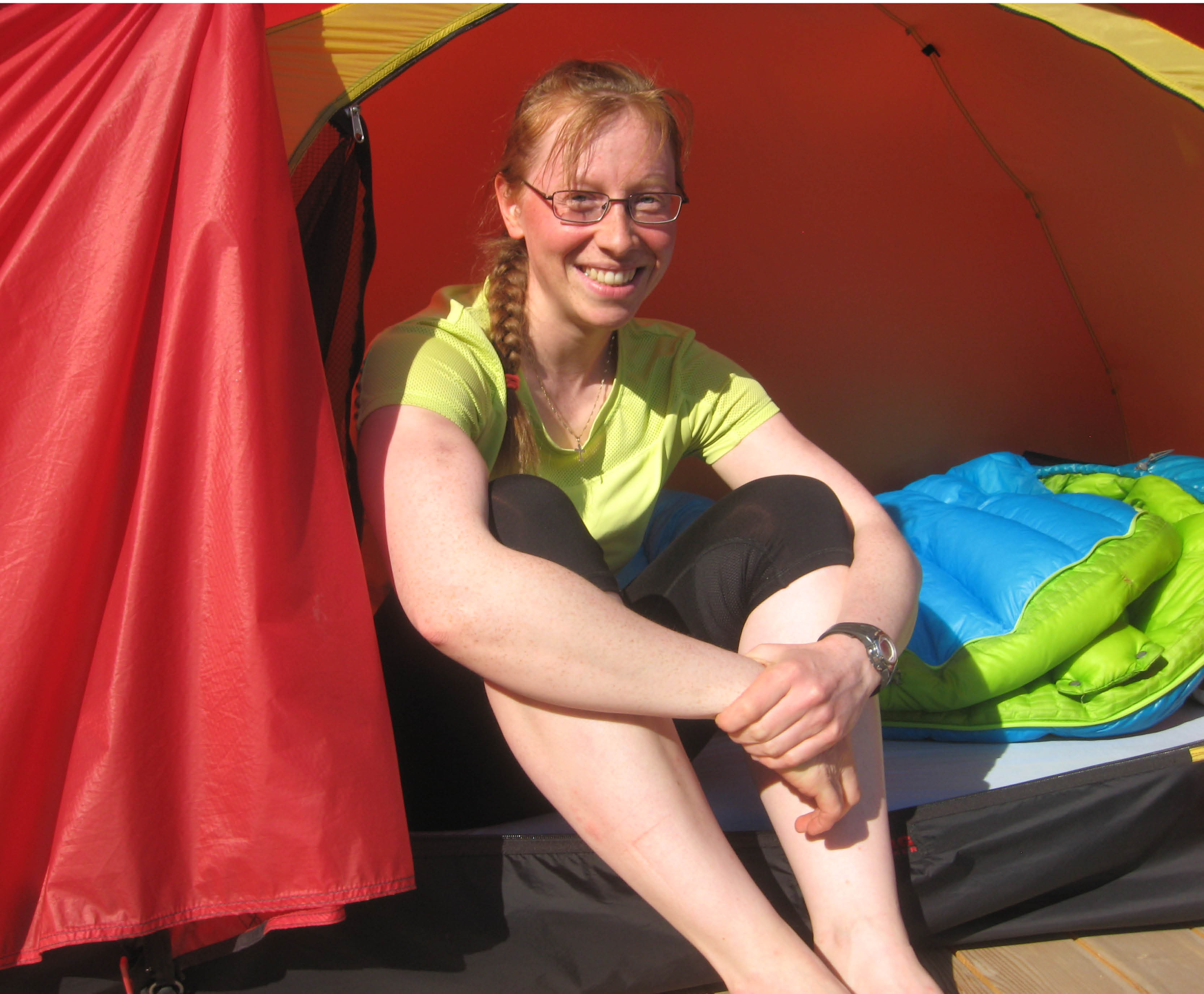 En leende Maarit sittades framför sitt tält.