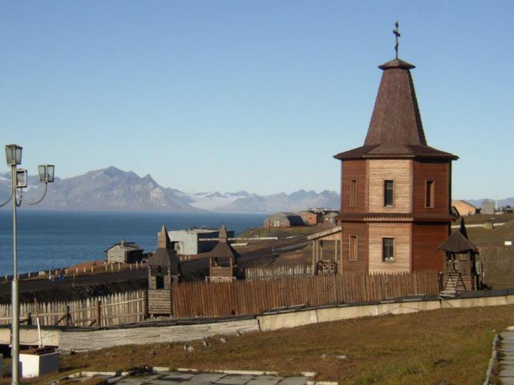 en bild av en träkyrka i ortodox stil.